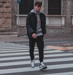 man in black jacket standing on pedestrian lane during daytime