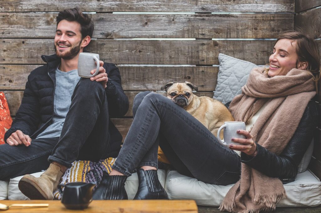 merry christmas, man, woman, dog, pet, pug, owners, couple, relationship, warm clothes, cozy, scarf, jackets, jeans, boots, fashion, people, happy, love, female, young, male, adult, caucasian, happiness, romantic, portrait, smile, smiling, girlfriend, animal, date, boyfriend, together, person, lovers, sitting, relaxing, rustic, cushions, couch, laughing, enjoying, coffee